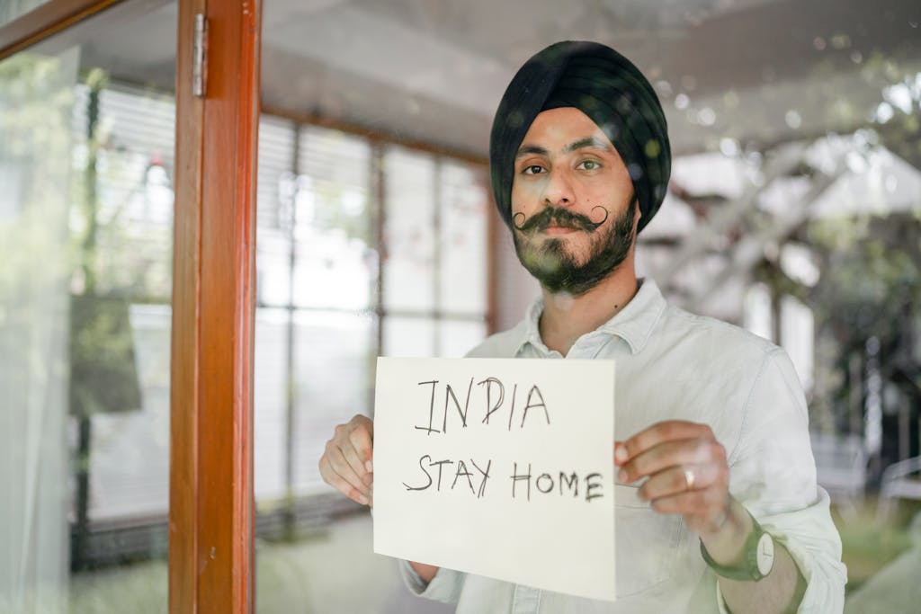 Bearded modern Sikh with paper in hands behind glass wall
