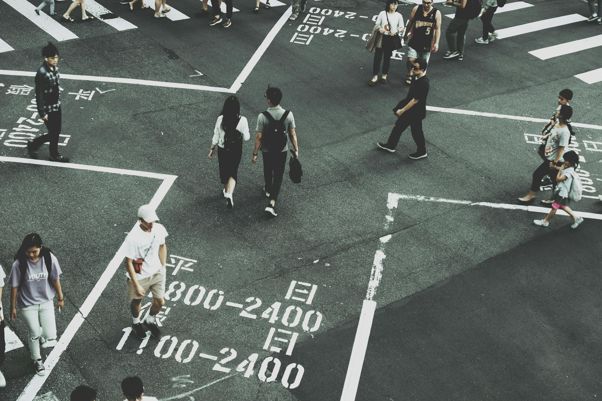 Aerial view of people crossing a busy intersection in Taipei's city center.