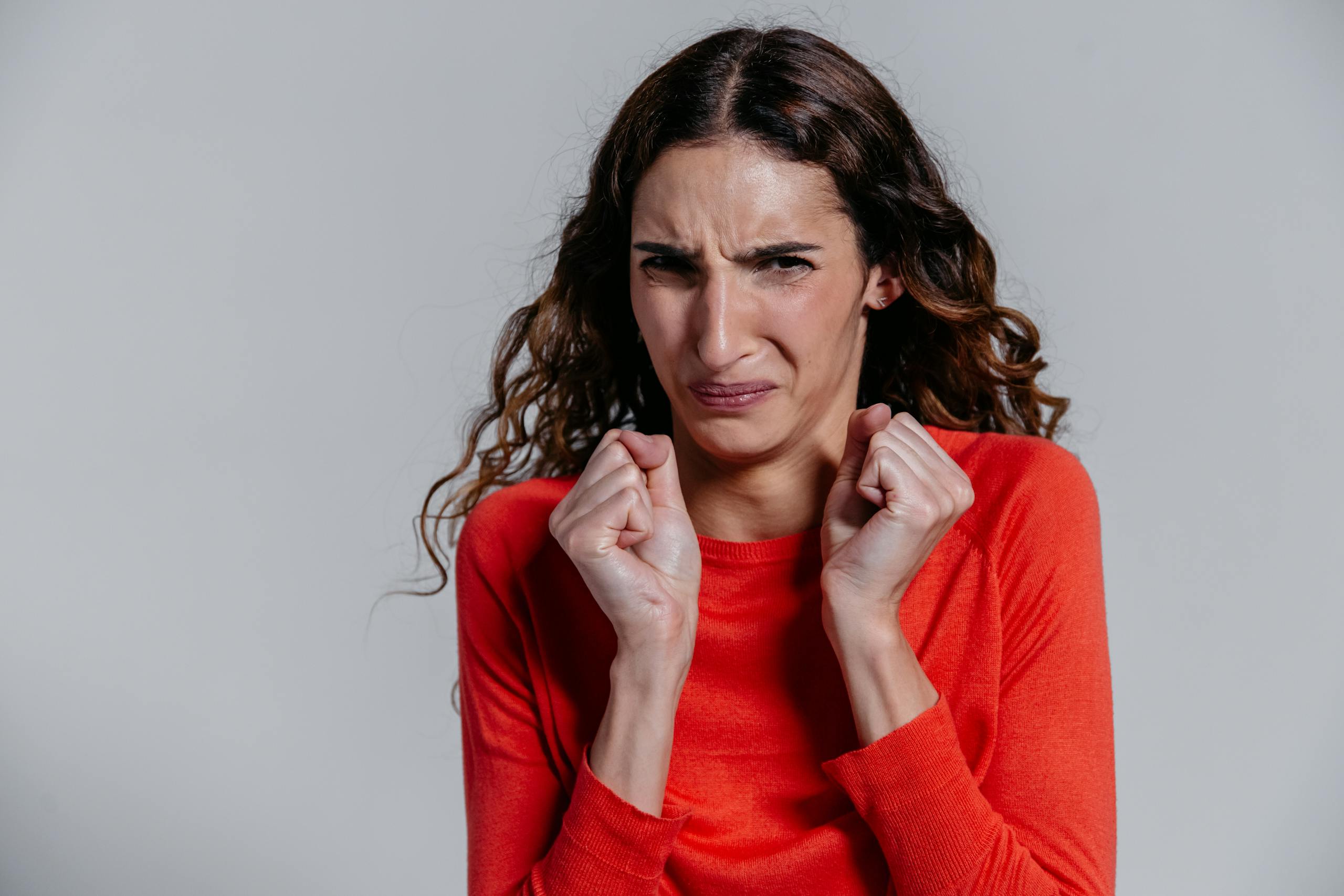 A woman displaying a disgusted facial expression indoors.
