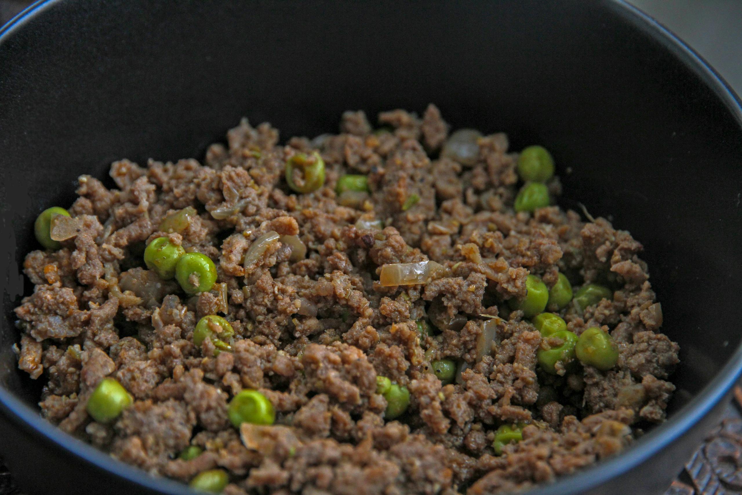 Close-up of a savory dish with minced meat and peas, ideal for culinary themes.