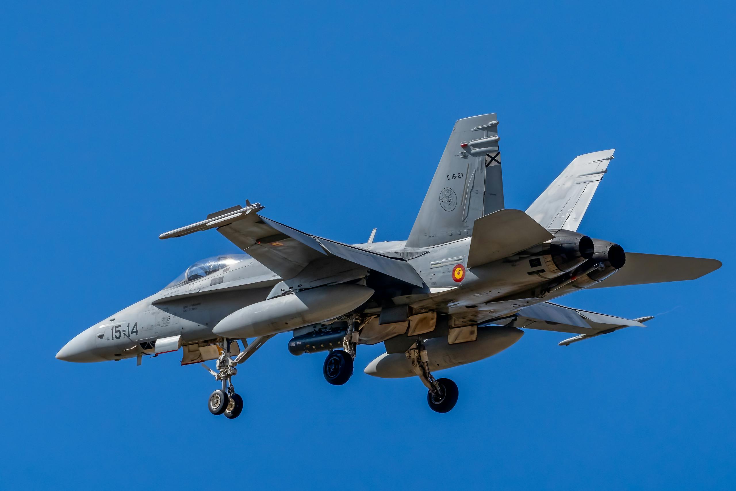 Close-up of a Spanish Air Force F/A-18 Hornet flying against a clear blue sky.