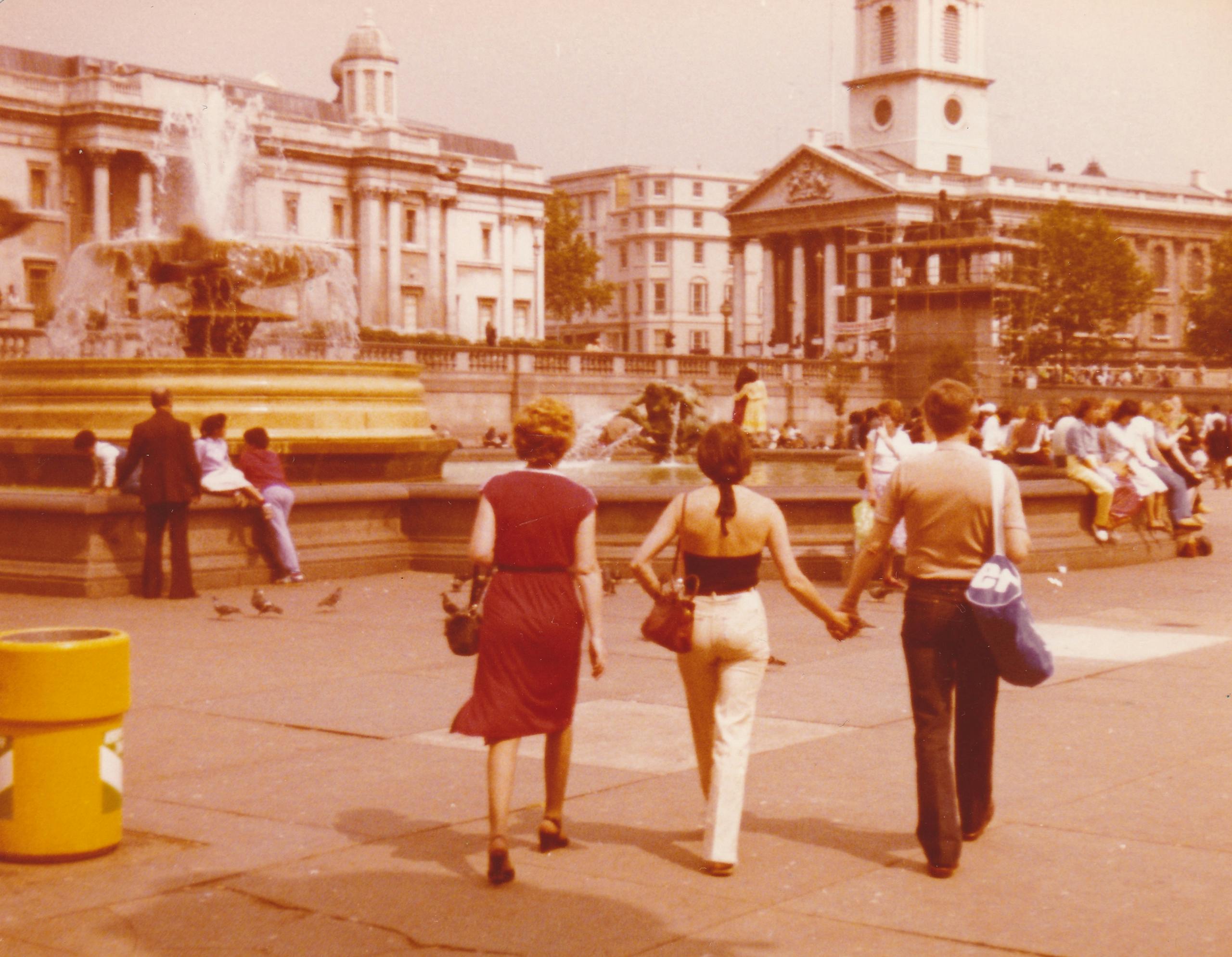 Retro photograph capturing people walking at Trafalgar Square with classic sepia tone.