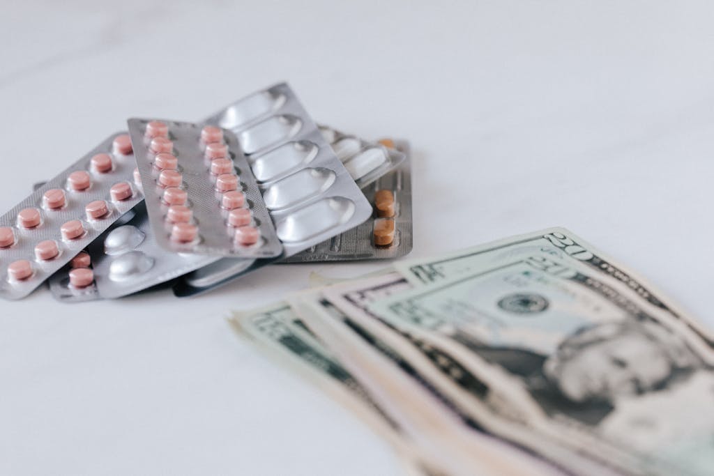 Close-up of medicine blister packs and U.S. currency illustrating healthcare costs.